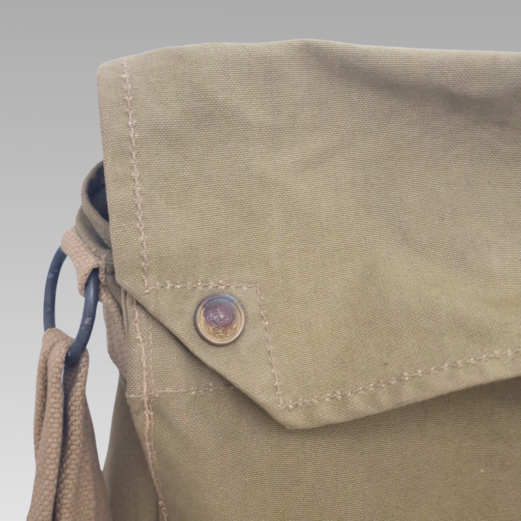 Close-up of respirator bag flap and metal press-stud fastening.